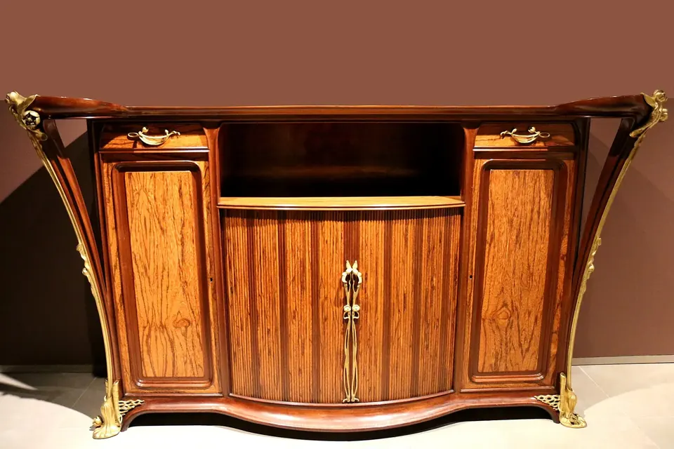 Meuble d'appui en bois précieux aux formes courbes, avec des ferrures en bronze doré évoquant des nénuphars